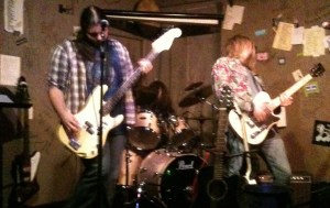 Scruffy & The Janitors jamming live at The Cafe Acoustic on November 17th, 2012. Lead singer/bassist Steven Foster on the left, drummer Trevin Newton in the middle and guitarist Teriq Newton on the right. Scruffy & The Janitors jamming live at The Cafe Acoustic on November 17th, 2012. Lead singer/bassist Steven Foster on the left, drummer Trevin Newton in the middle and guitarist Teriq Newton on the right.