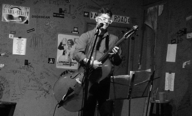 Christopher Bell plays his electric cell like a guitar as he would loop each part of his songs for the effect of a full band at Cafe Acoustic in St. Joseph, Missouri on 6/26/14.